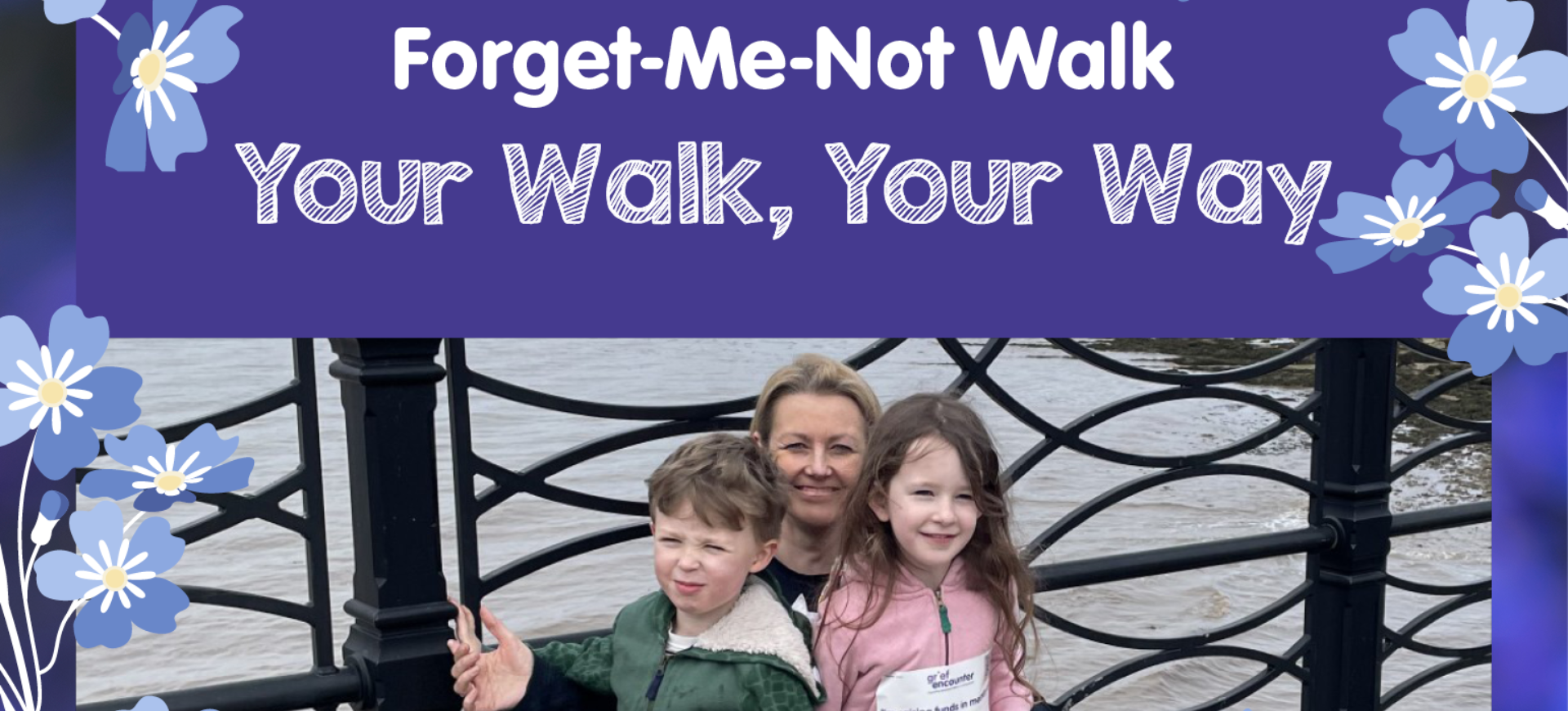 A woman and two children pose by a riverside railing, surrounded by a graphic border with blue forget-me-not flowers and text reading 